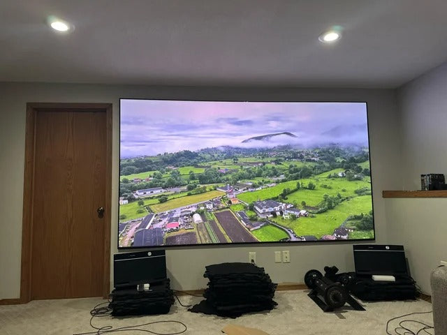 Customer photo of a 130-inch WUPRO Ultra Contrast anti-laser speckle lenticular CLR projection screen paired with a Valerion projector in a bright, lights-on room